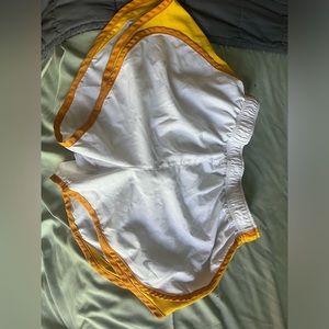 White Nike shorts with bright and mustard yellow on the sides